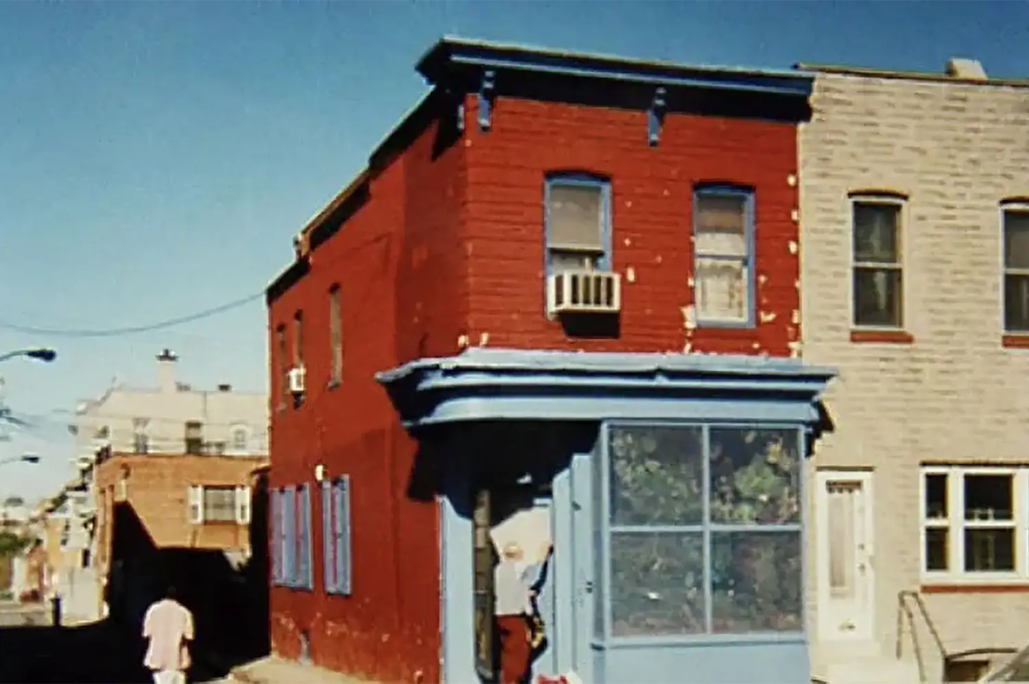 A two-story building painted in a bright red with light blue-trimmed windows.